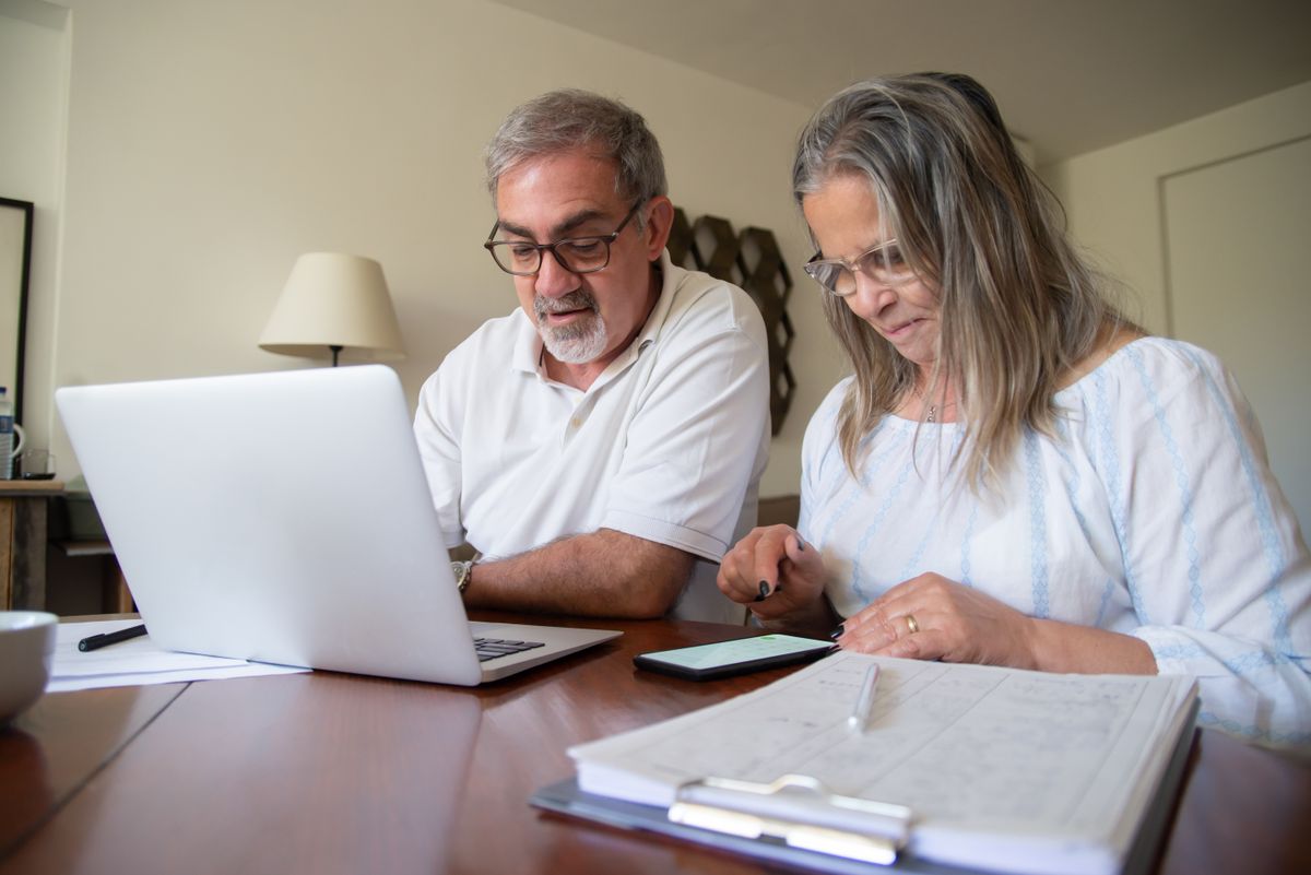 Couple de retrait&eacute;s comparant des offres de mutuelle sant&eacute; sur un ordinateur portable